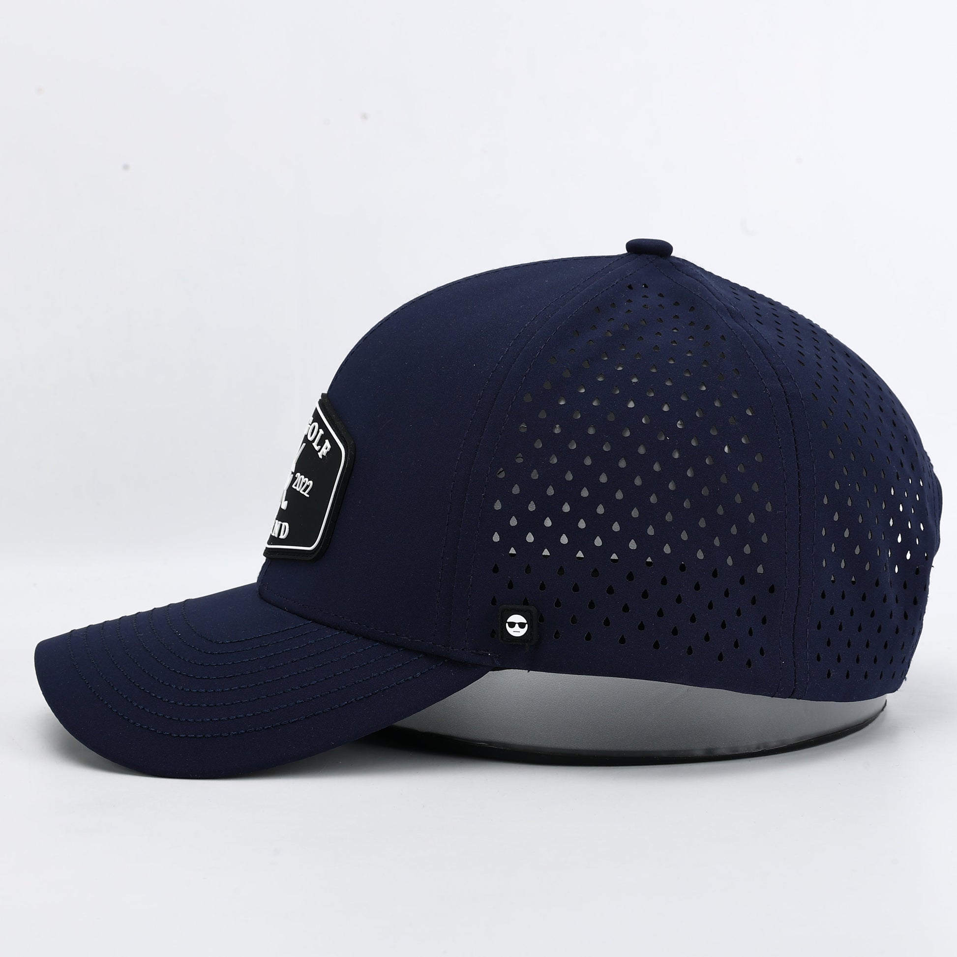Navy blue baseball cap with perforated design on a white background. The Summit Collection x Bad Golf Brand