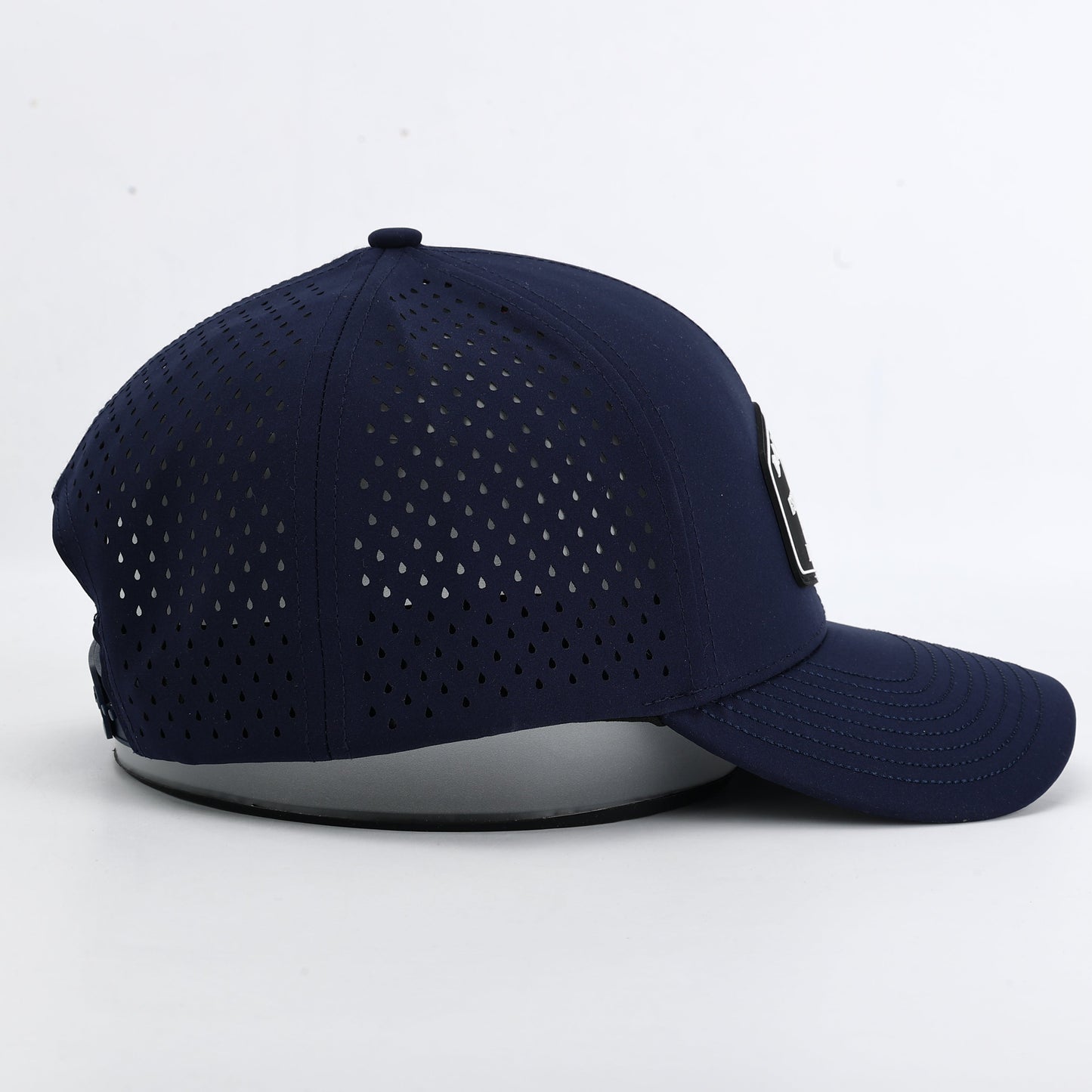 Navy blue baseball cap with perforated design on a white background. The summit collection by Bad Golf Brand