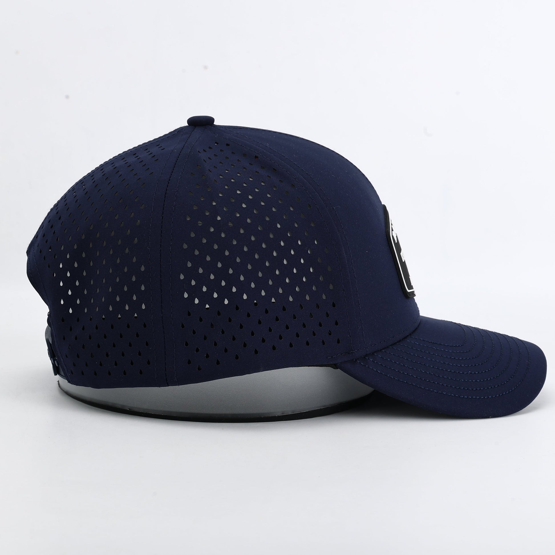 Navy blue baseball cap with perforated design on a white background. The summit collection by Bad Golf Brand