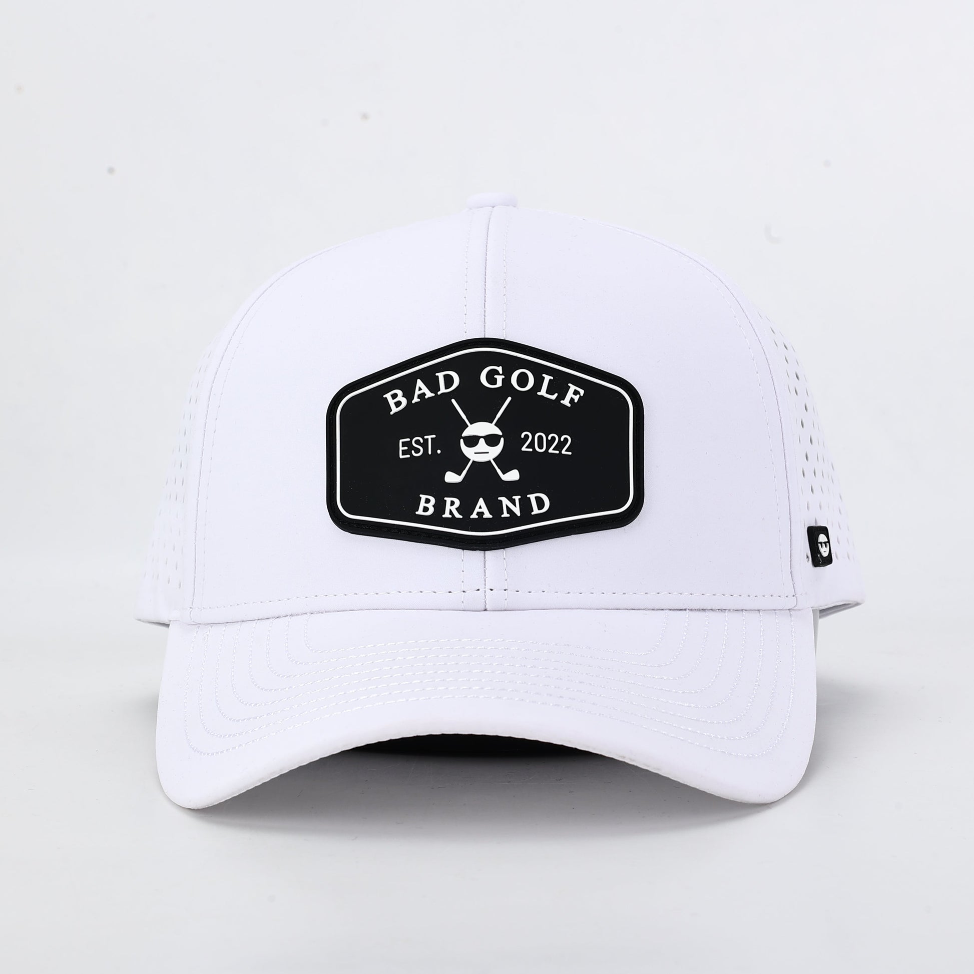 White cap with a black logo on a light gray background. The summit collection by Bad Golf Brand.